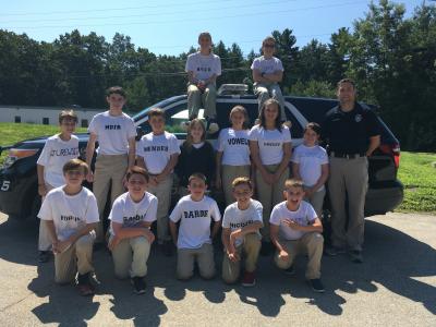 2017 Youth Police Academy Class posing infront of marked police cruiser